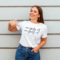 Woman with brown hair wearing white tee that says everybody cut