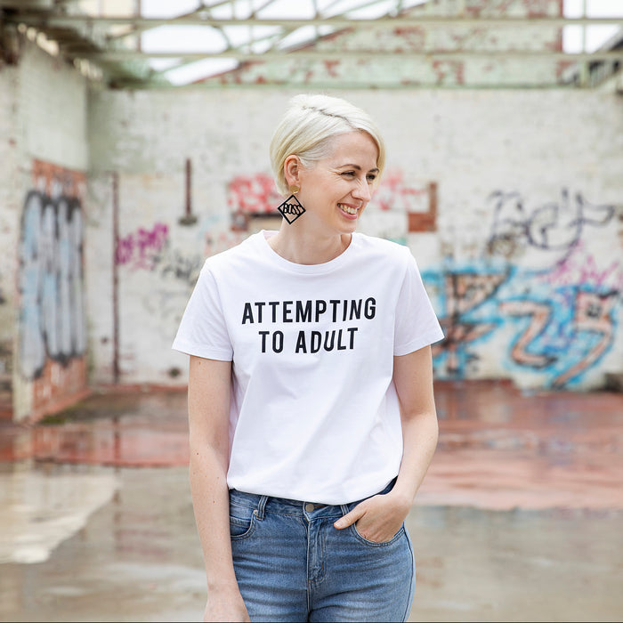Slightly Shirtee Attempting to Adult Slogan White Tshirt worn by woman with blonde hair wearing denim jeans